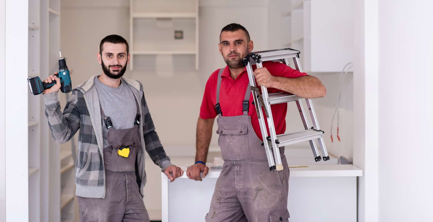 Two handymen posing after a kitchen installation
