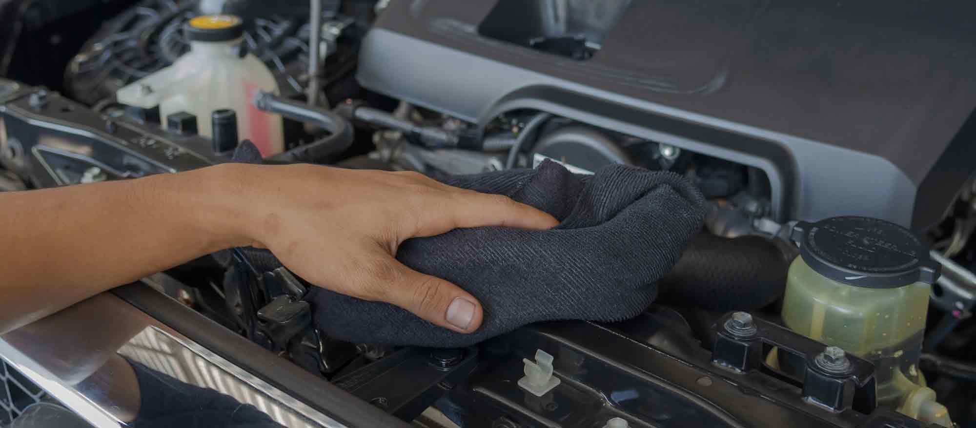 Hand wiping an engine with a cloth