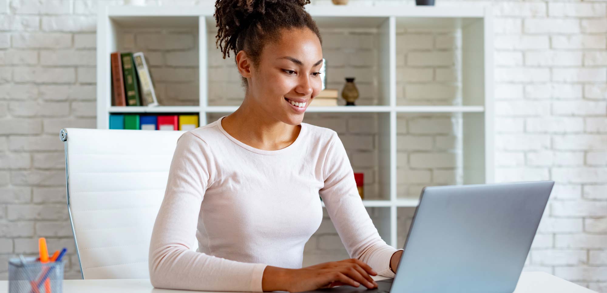 Woman smiling while working on a laptop